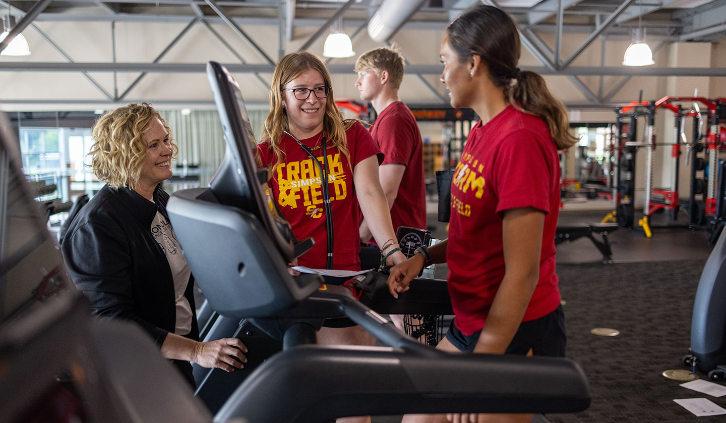 Students and faculty interact in fitness center during class