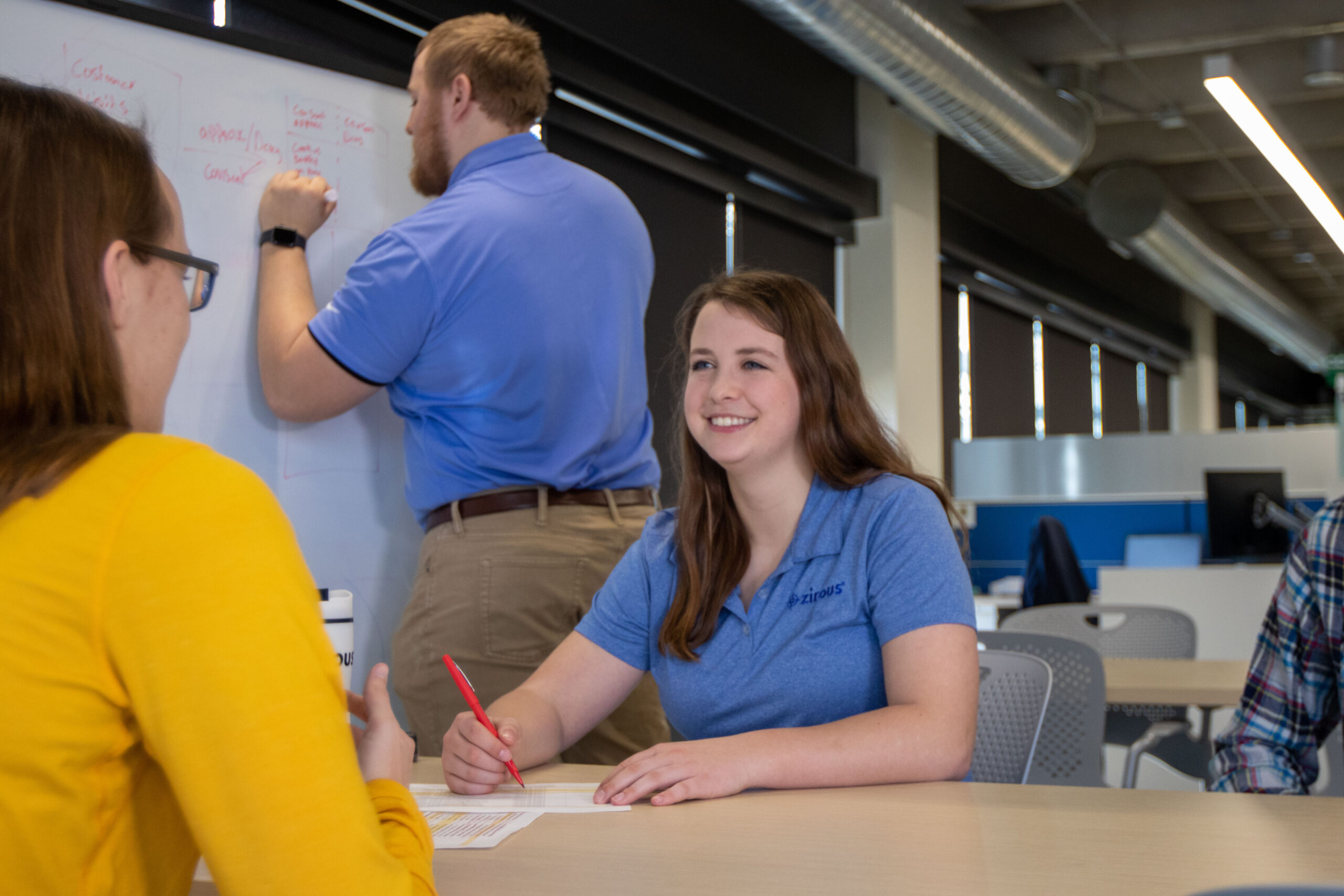 Simpson graduate working on data with coworkers